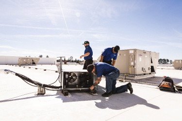 DOC technicians servicing commercial HVAC unit